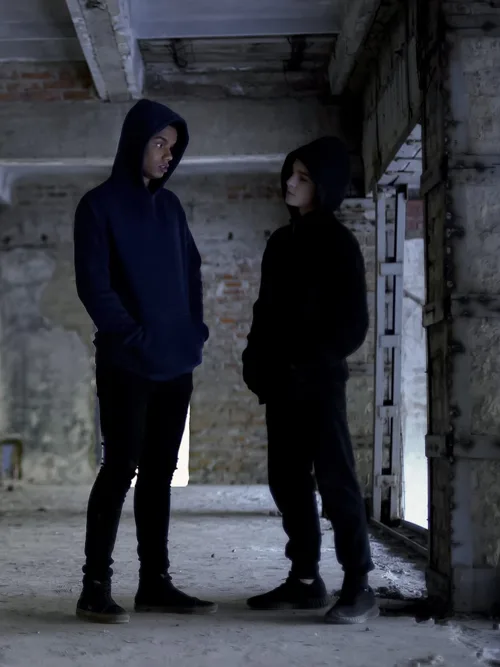 Two young people standing face to face in a brick building